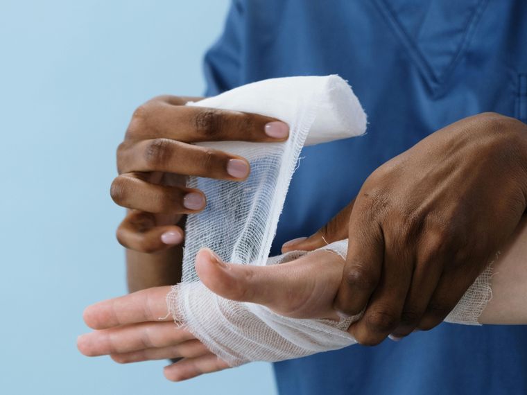 Clinician dressing a patient's injured hand