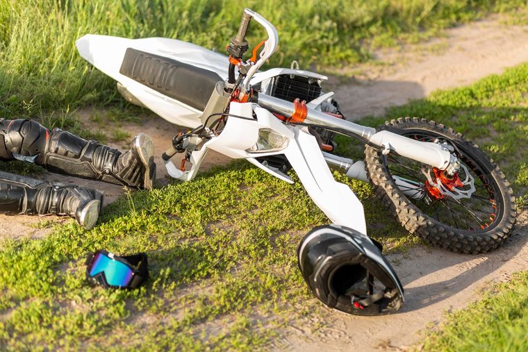 Motorcycle down on a trail beside the rider's gear